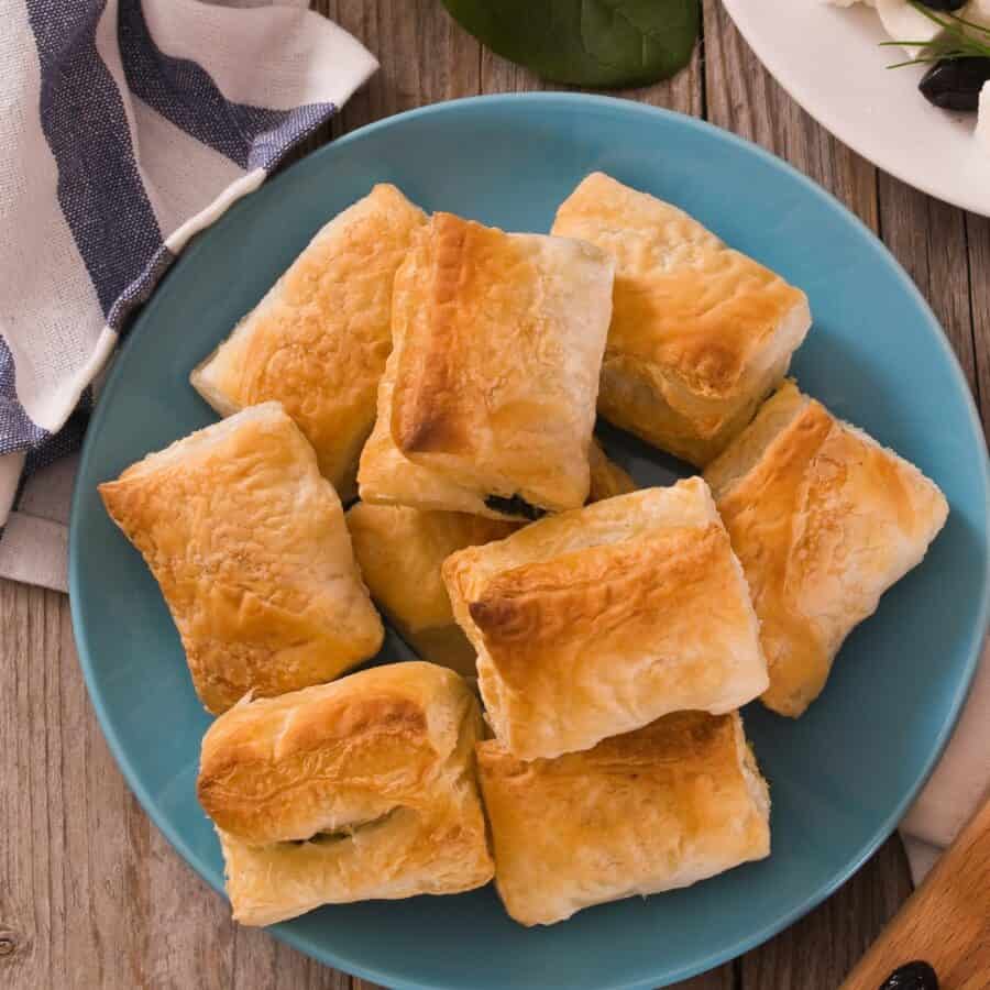 overhead image of spinach puffs stacked on a plate