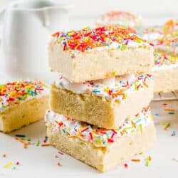 Chocolate chip cookie Sugar Cookie Bars stacked on top of eachother on a bright white surface