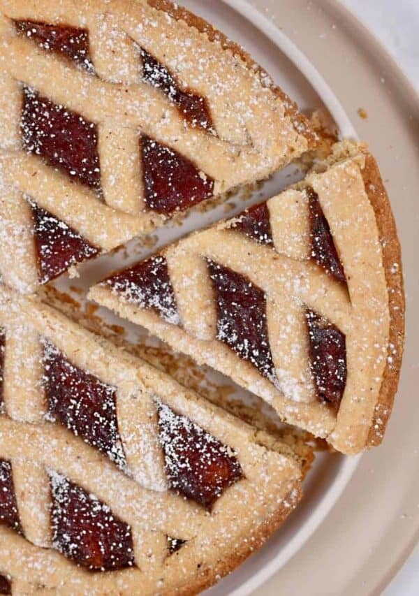 Overhead image of a piece being taken out of a linzer tart