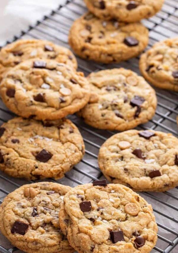 A dozen salted caramel chocolate chip cookies on a cooling rack