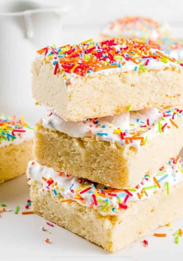 Sugar Cookie Bars stacked on top of eachother on a bright white surface
