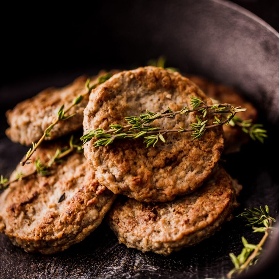 Close up image of air fryer sausage patties on a dark plate