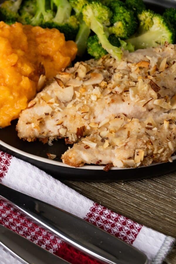 Almond Crusted Chicken on a plate with side dishes