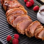 Close Up image of bacon wrapped pork tenderloin with raspberries next to it - 8