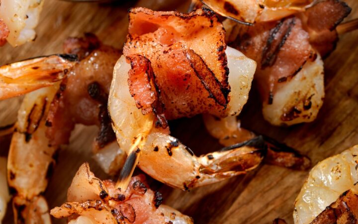 Bacon Wrapped Shrimp on a cutting board with a side of mustard - 5