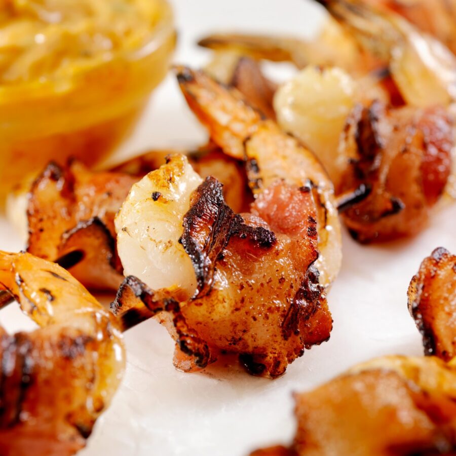 Close up image of bacon wrapped shrimp on a bright background - 3