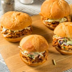 Four Bufflao Chicken Sliders on a wooden cutting board