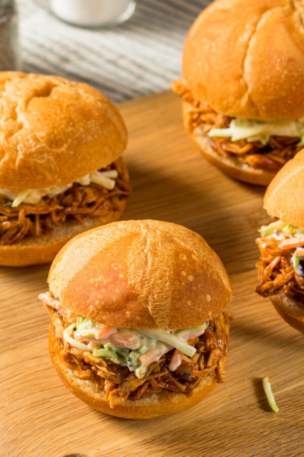 Four Bufflao Chicken Sliders on a wooden cutting board