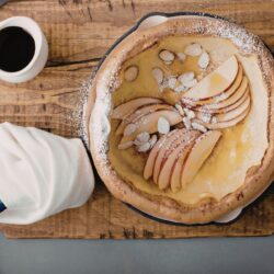 Overhead image of Dutch Baby in a skillet with apples and almonds