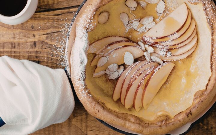 Overhead image of Dutch Baby in a skillet with apples and almonds