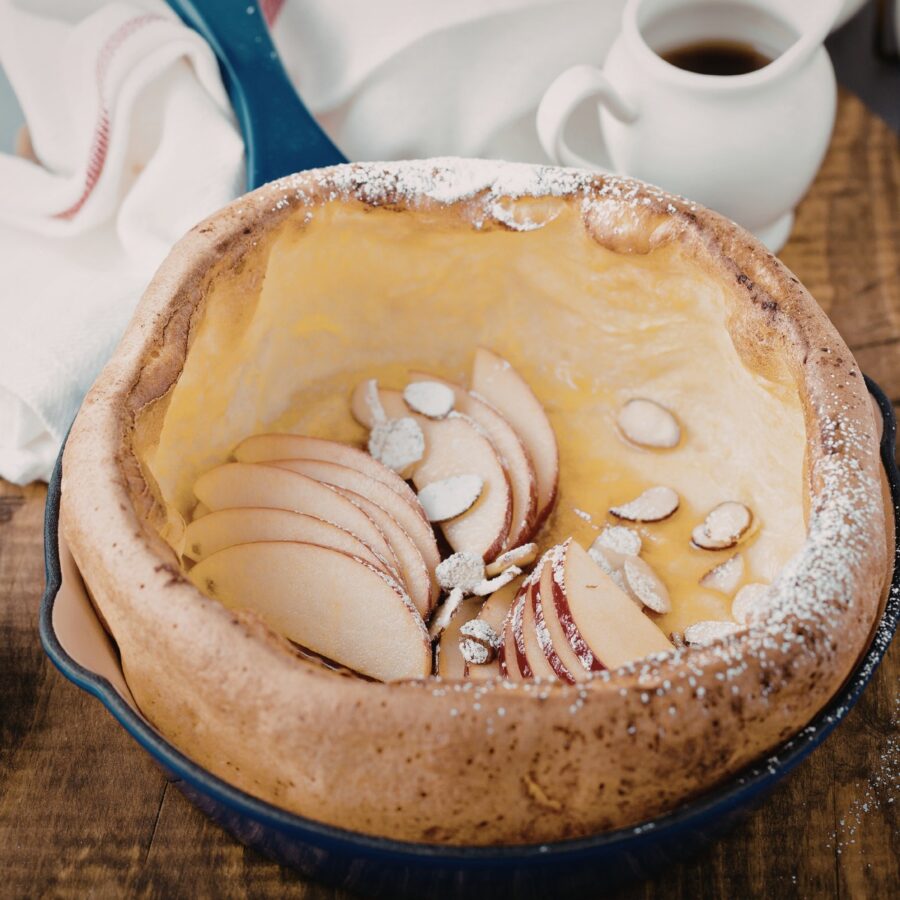 Close up image of a dutch baby with apples and almonds