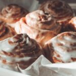 close up image of protein cinnamon rolls in a pan with parchment paper - 8