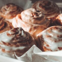 close up image of protein cinnamon rolls in a pan with parchment paper