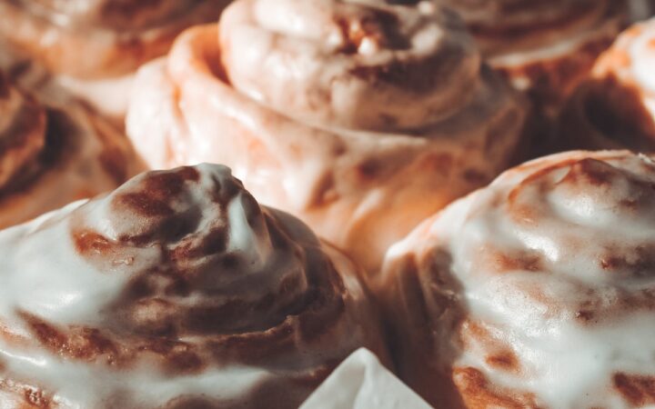 close up image of protein cinnamon rolls in a pan with parchment paper - 13