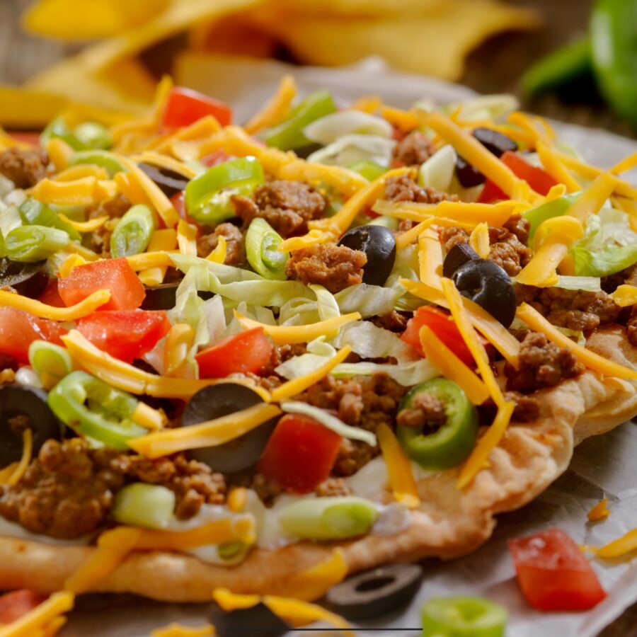 Close up image of taco pizza on parchment paper