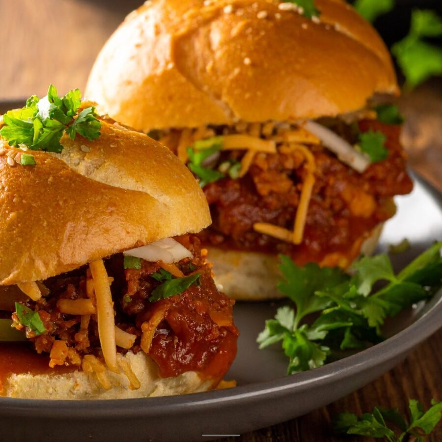 Close up image of two turkey sloppy joes on a plate with herb garnish