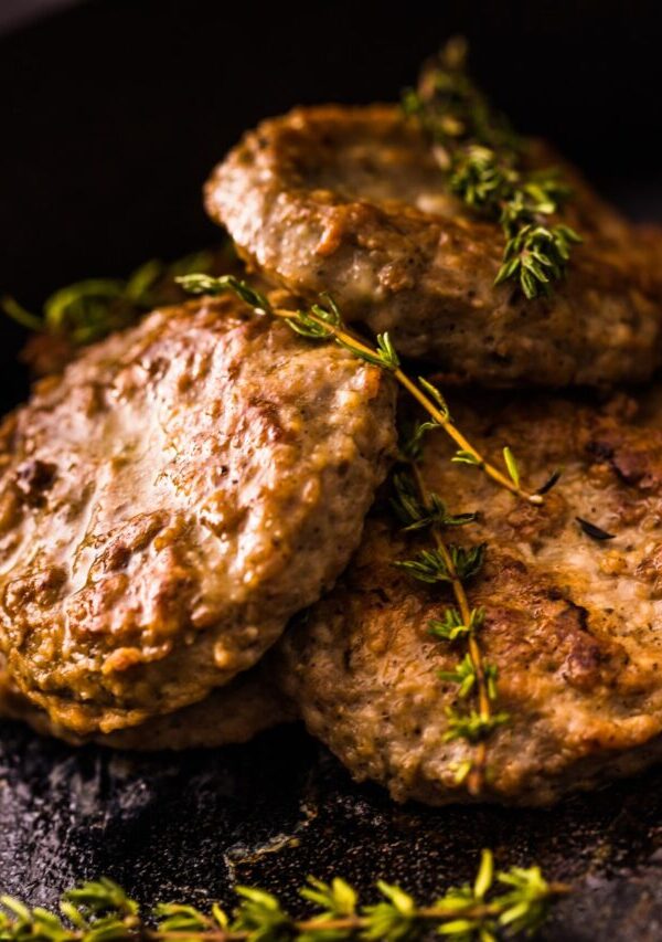 Air Fryer Sausage Patties on a black plate with herb garnish