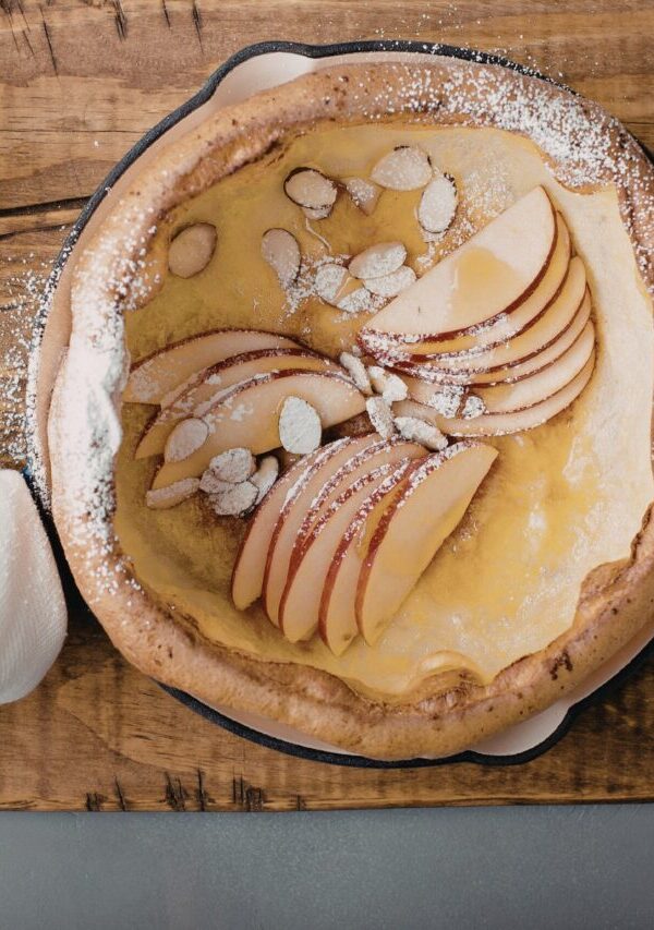 Overhead image of Dutch Baby in a skillet with apples and almonds