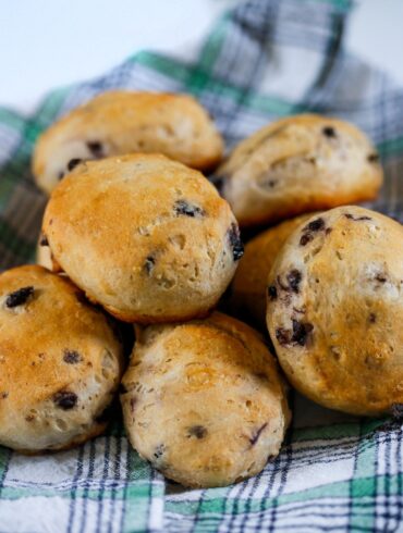 Blueberry Biscuits on a plaid cloth stacked in a pile