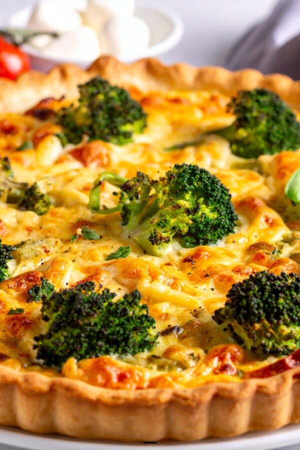 A Broccoli Quiche uncut on a white plate