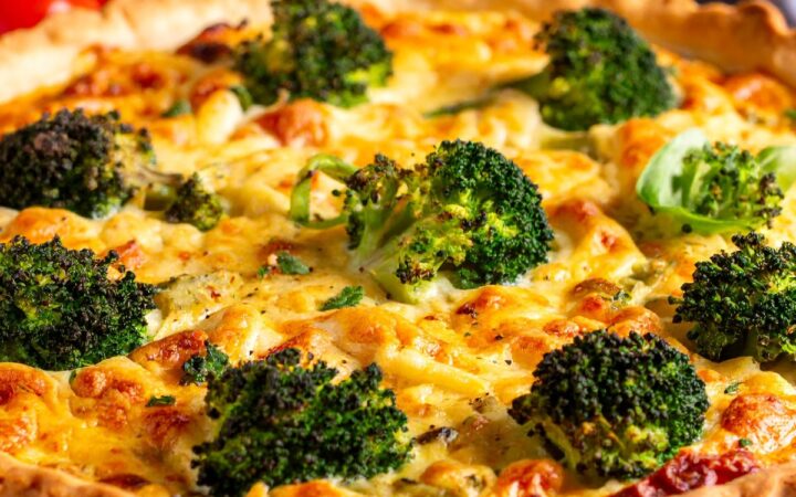 A Broccoli Quiche uncut on a white plate - 27