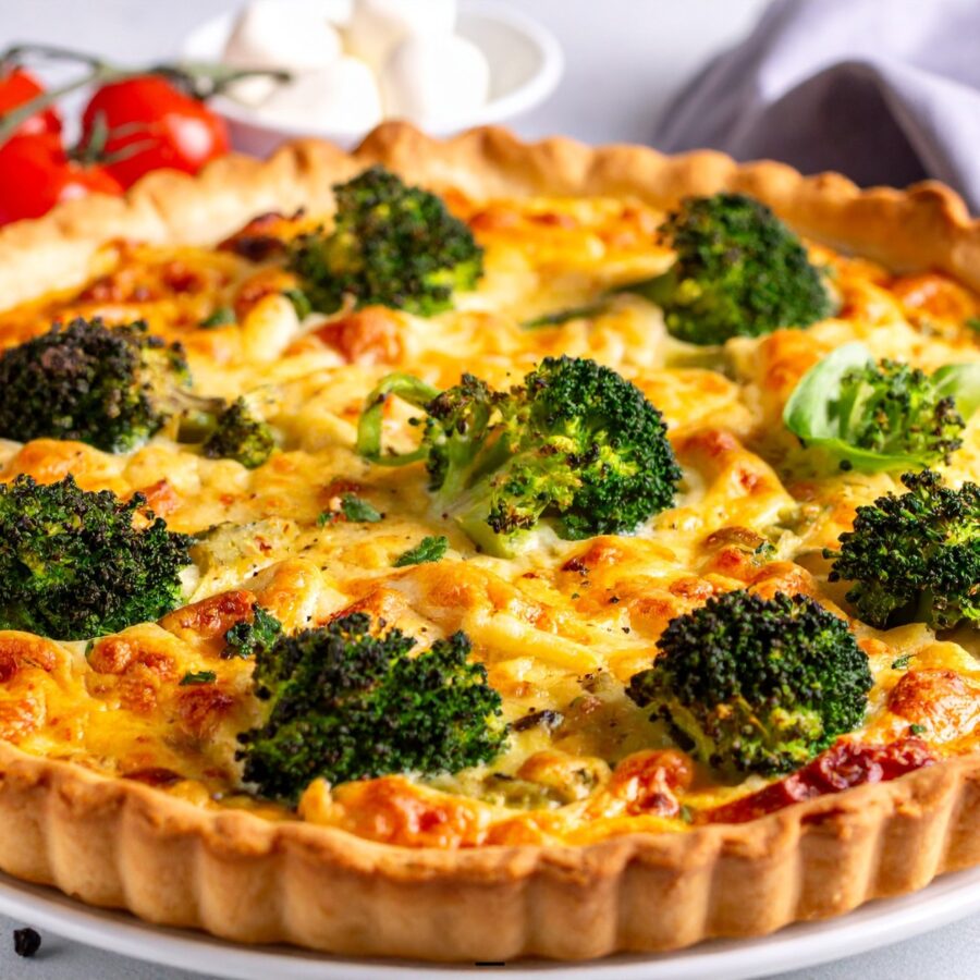 A Broccoli Quiche uncut on a white plate - 24
