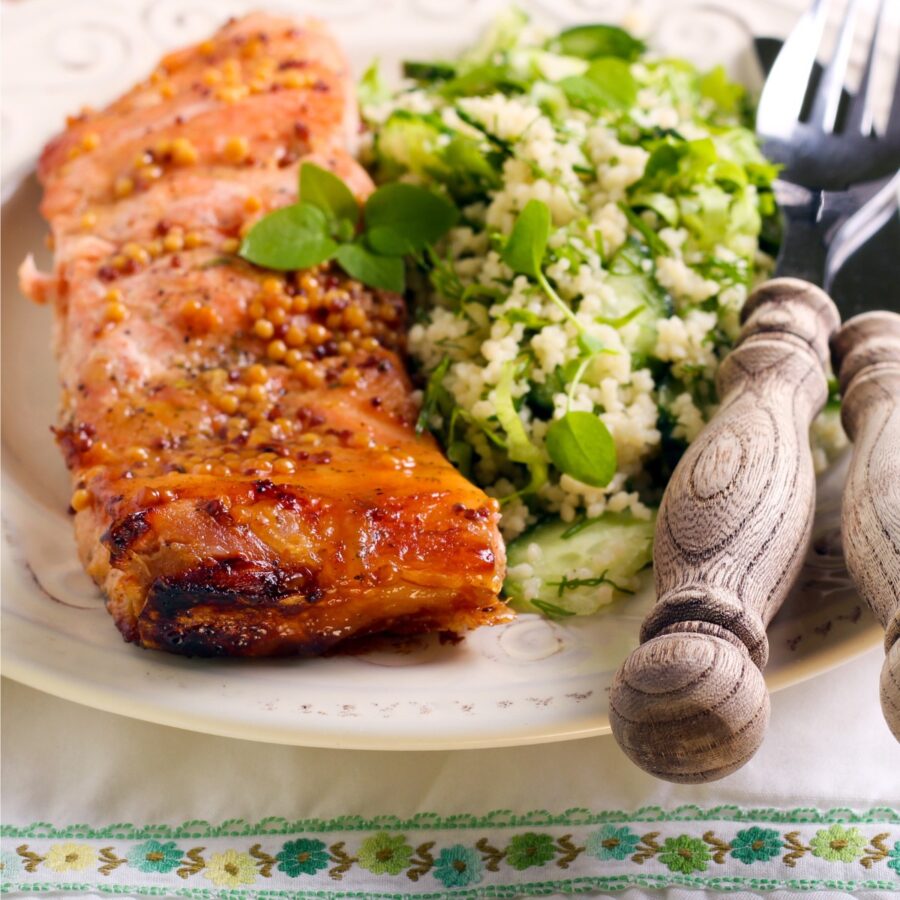 Close up image of hot honey salmon on a plate with salad
