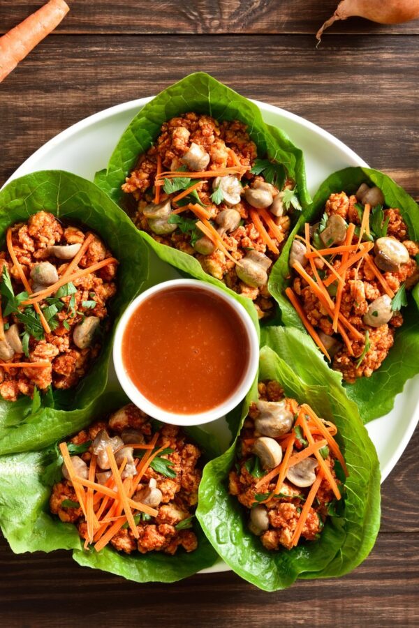 Korean Lettuce Wraps on a plate with a dipping sauce in the middle
