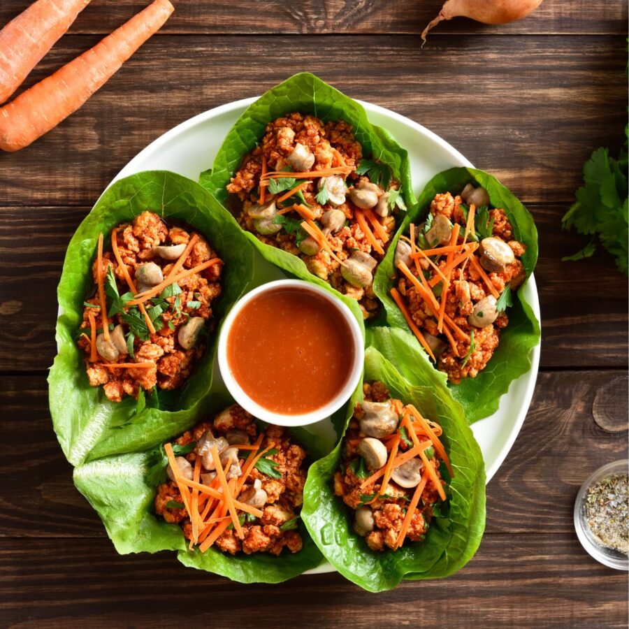 Korean Lettuce Wraps on a plate with a dipping sauce in the middle
