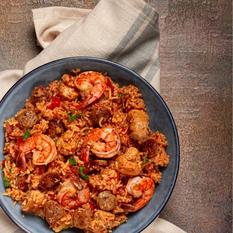 Close up image of paella on a blue plate with a napkin under it