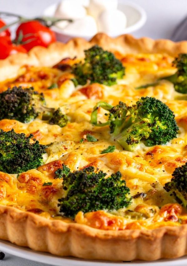 A Broccoli Quiche uncut on a white plate