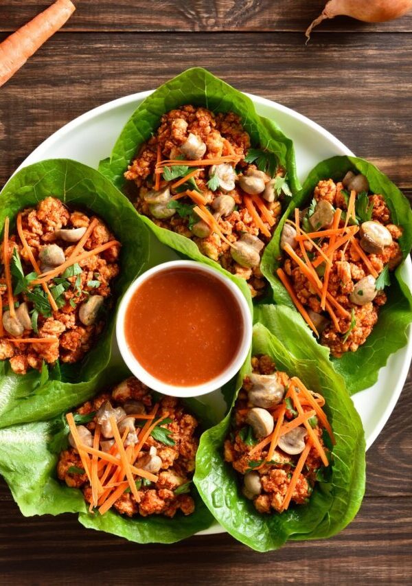 Korean Lettuce Wraps on a plate with a dipping sauce in the middle