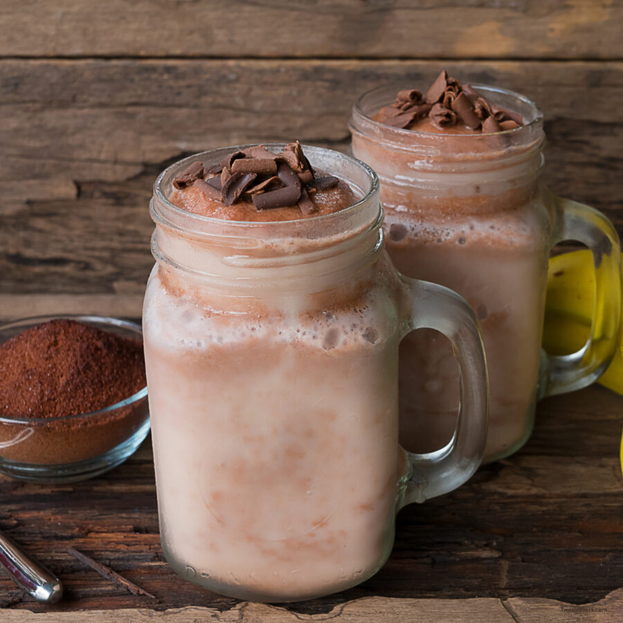two coffee smoothies in mason jars on a wooden surface