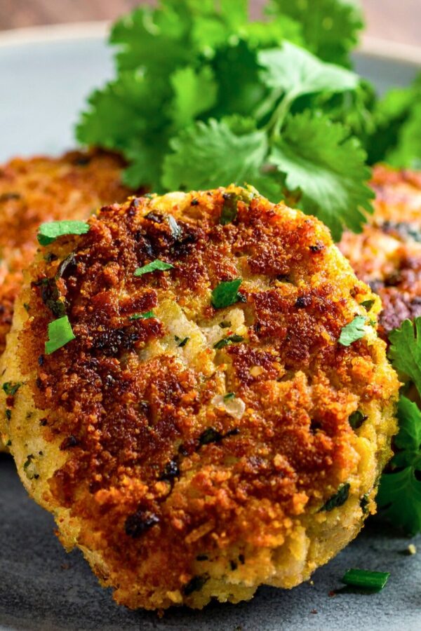 Close up image of Crab cakes on a plate with herb garnish