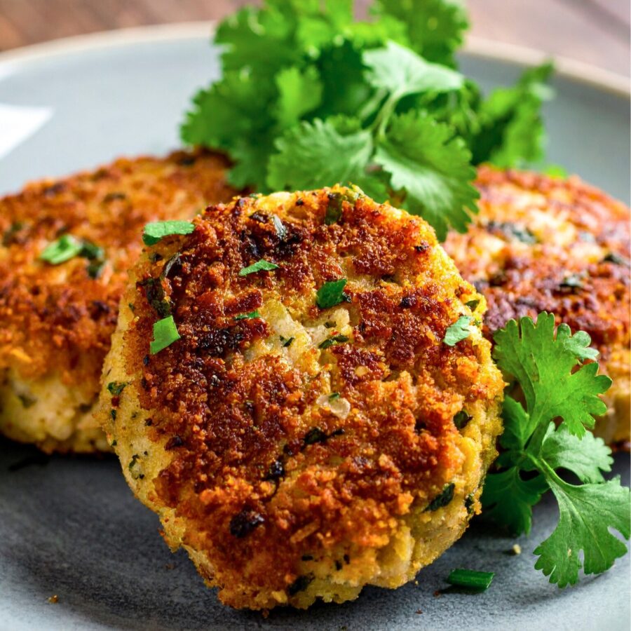 Close up image of Crab cakes on a plate with herb garnish