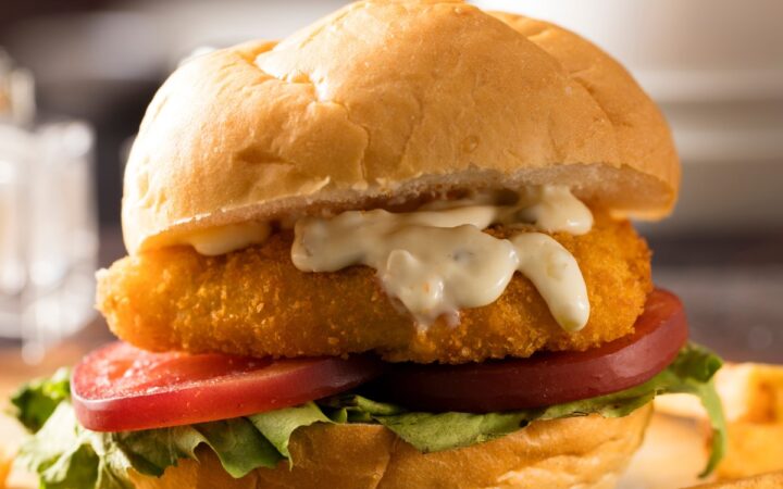 Fried Frish Sandwich on a rustic surface with french fries