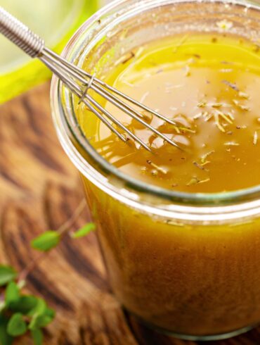 Lemon Vinaigrette in a glass jar with a small whisk