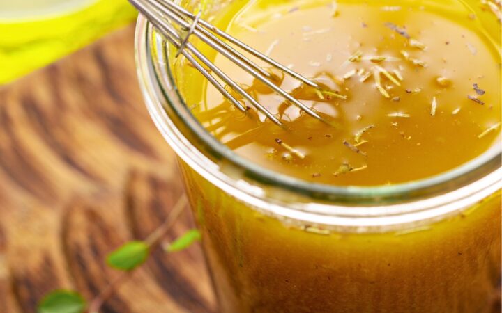 Lemon Vinaigrette in a glass jar with a small whisk