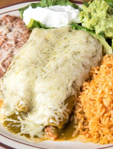 Overhead image of Turkey Enchiladas on a plate with beans and rice