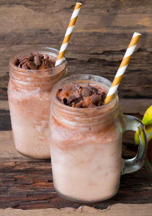 Two coffee smoothies with straws in them
