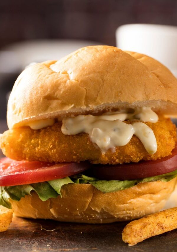 Fried Frish Sandwich on a rustic surface with french fries