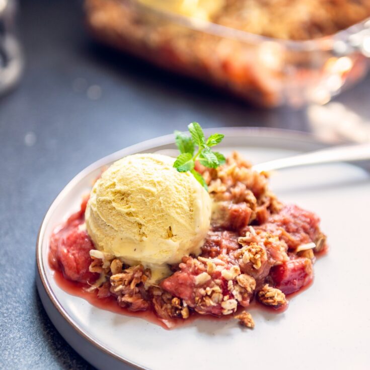 Strawberry Rhubarb Crisp on a plate with ice cream