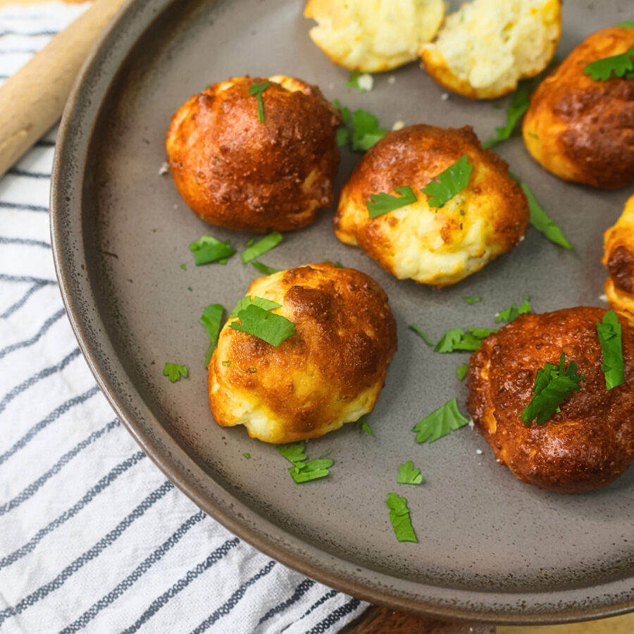 Close up image of Air Fryer Protein Cheese bites on a plate with herb garnish