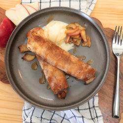 Overhead image of two Air Fryer Apple Pie Taquitos on a plate with ice cream