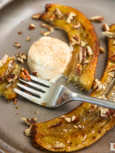 Close up image of air fryer carmelized bananas on a plate with a bite on a fork