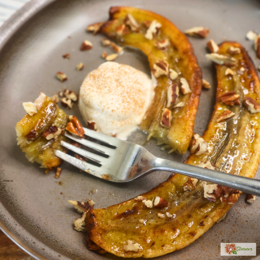 Close up image of air fryer carmelized bananas on a plate with a bite on a fork