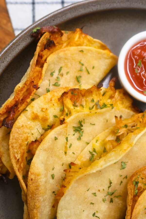 Close up image of Air Fryer Crispy Chicken Tacos on a plate with salsa