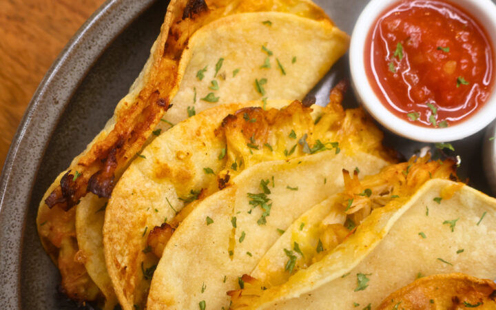 Close up image of Air Fryer Crispy Chicken Tacos on a plate with salsa
