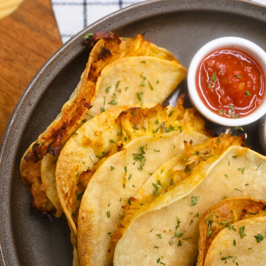 Close up image of Air Fryer Crispy Chicken Tacos on a plate with salsa