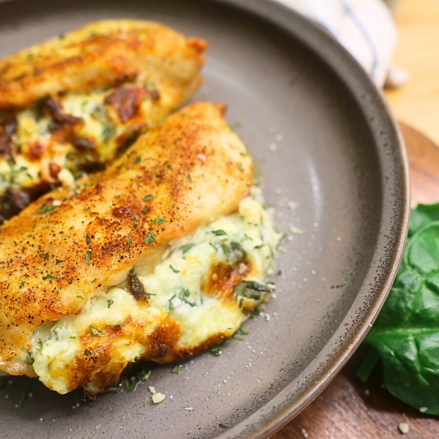 Close up image of two air fryer stuffed chicken breasts on a plate
